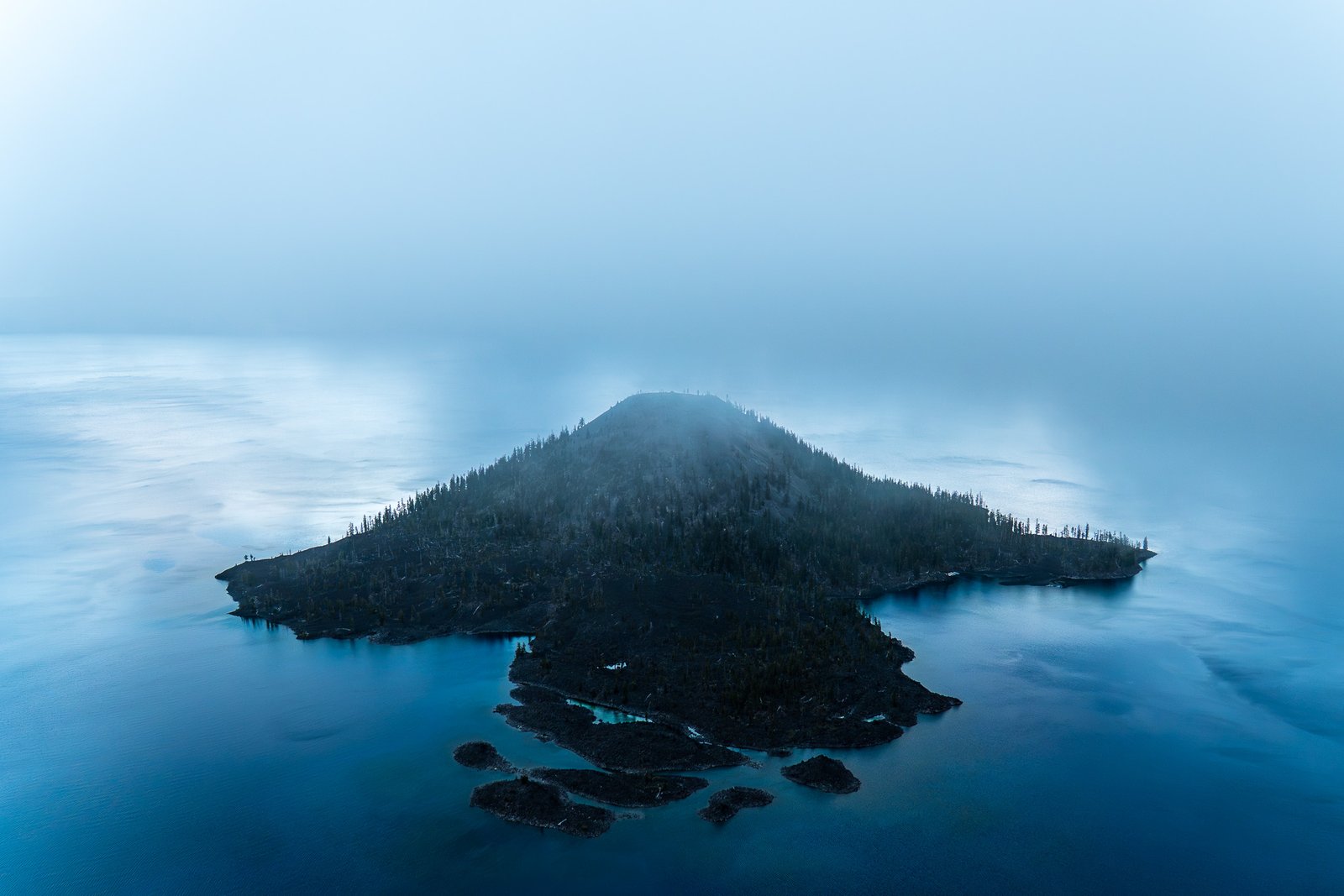 Wizard Island entre la niebla en Crater Lake